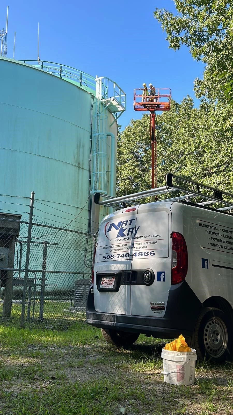 Nat Kay crew painting a large water tank using a boom lift