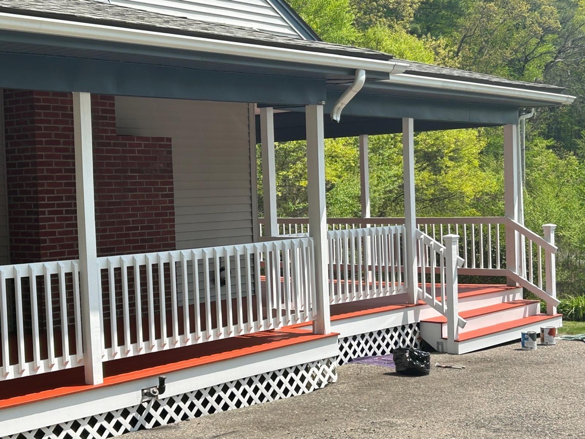 Same porch after painting, white rails and red floor