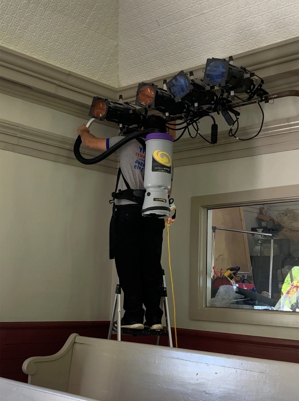 Nat Kay team cleaning high ceiling fixtures in a commercial building